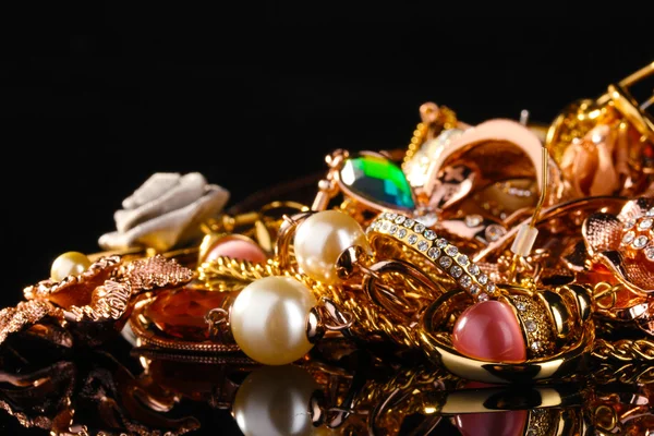 Various gold jewellery on black — Stock Photo, Image