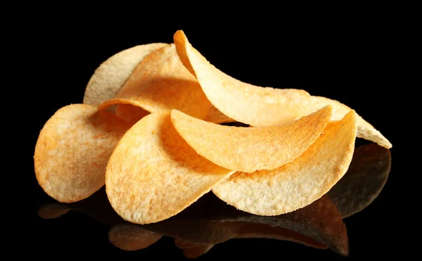 stock image Delicious potato chips on black background