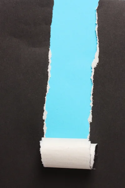 Zerrissenes schwarzes Papier mit blauem Hintergrund — Stockfoto