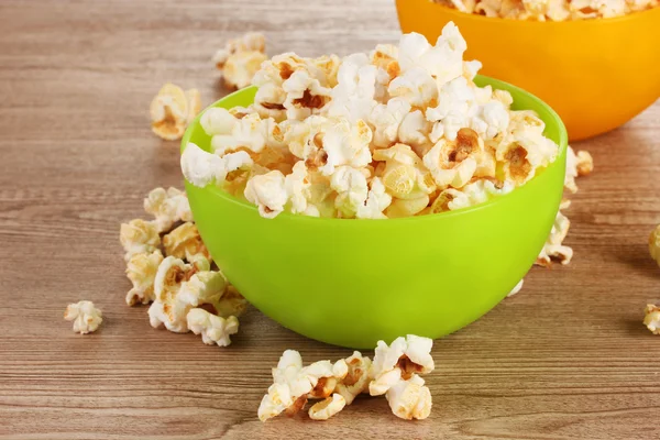 stock image Popcorn in bright plastic bowls on wooden table