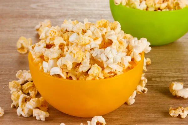 stock image Popcorn in bright plastic bowls on wooden table