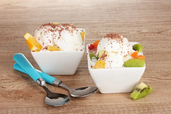 Pyszne lody waniliowe z czekolady i owoców o miseczki i łyżki — Zdjęcie stockowe