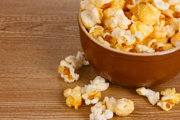 Popcorn in brown bowl on wooden table — Stock Photo, Image
