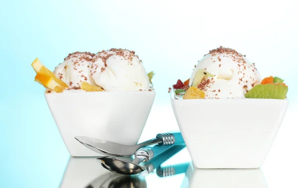 Delicioso helado de vainilla con chocolate y frutas en cuencos y cucharas o —  Fotos de Stock