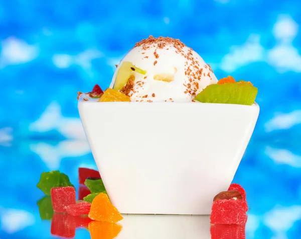 Pyszne lody waniliowe z czekolady i owoców w misce na niebieski backg — Zdjęcie stockowe