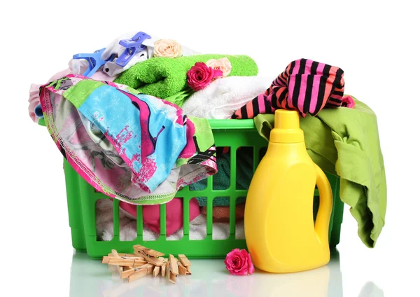 Roupas com detergente e em cesta de plástico verde, isoladas sobre branco — Fotografia de Stock