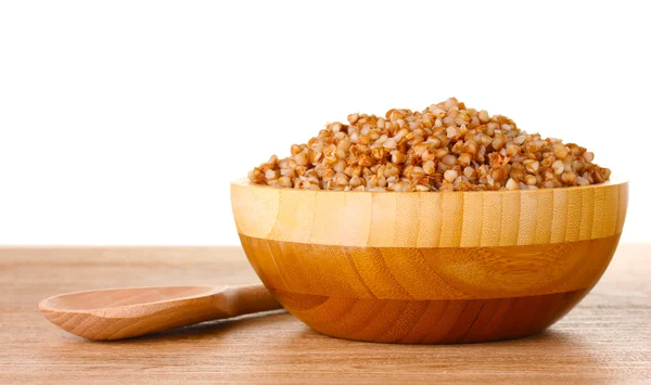 Boiled buckwheat in a wooden bowl on wooden table isolated on white — Stock Photo, Image