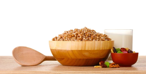 Buckwheat rebus dalam mangkuk kayu dengan segelas susu di atas meja kayu isol — Stok Foto