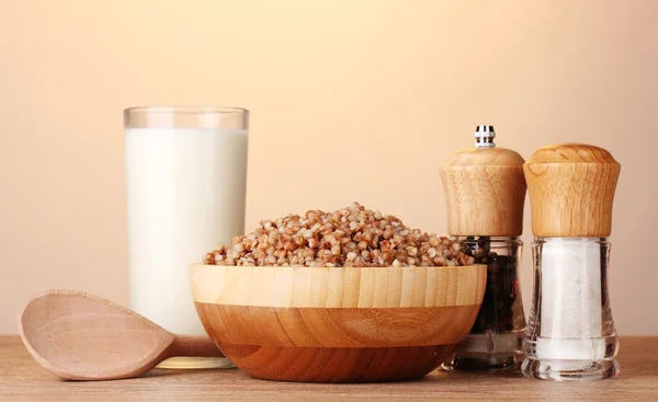 Vařená Pohanka v dřevěné misce se sklenicí mléka na dřevěný stůl na b — Stock fotografie