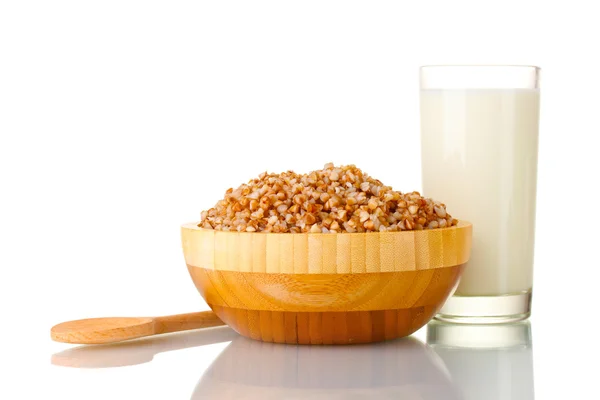 Trigo sarraceno hervido en un tazón de madera con un vaso de leche aislado en blanco — Foto de Stock