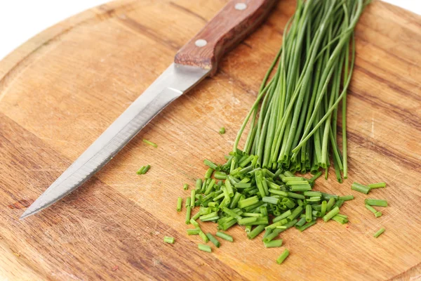 Schöne grüne Zwiebeln Schnittlauch und Messer auf Holzbrett Nahaufnahme — Stockfoto
