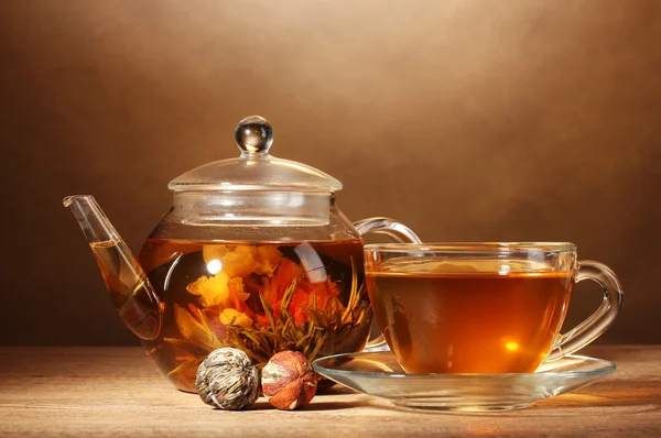 玻璃茶壶和异国情调绿茶棕色 backgro 上的木桌上的杯子 — 图库照片