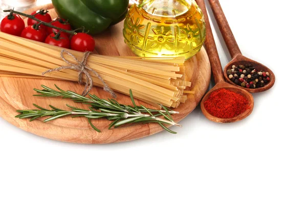 Spaghetti, burk med olja, kryddor och grönsaker på träplatta isolerad på wh — Stockfoto
