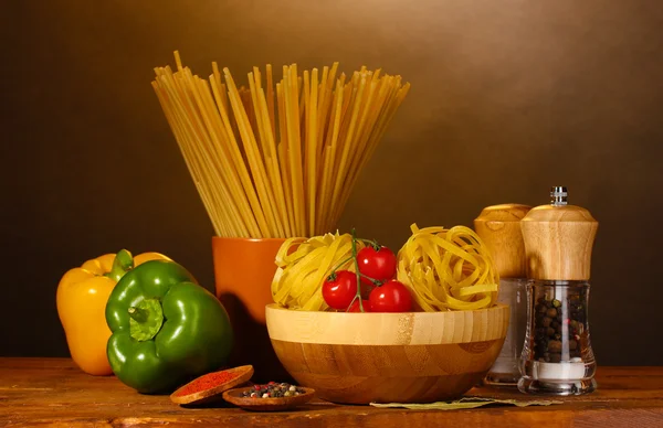 Spaghetti, noodles in bowl, paprika tomatoes cherry on wooden table on brow