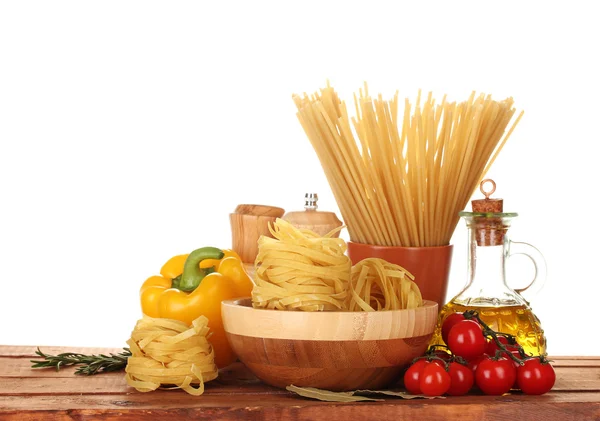Spaghetti, tagliatelle in ciotola, vasetto di olio e verdure su tavola di legno isola — Foto Stock