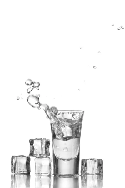 Vodka de vidrio y hielo aislado en blanco —  Fotos de Stock