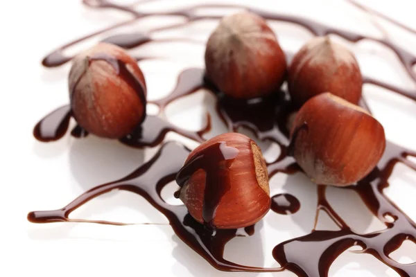 Lezzetli fındık ve çikolata şurubu üzerine beyaz izole — Stok fotoğraf