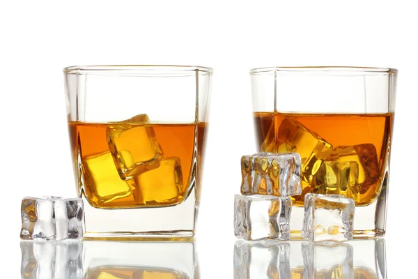Due bicchieri di whisky scozzese e ghiaccio isolato su bianco — Foto Stock