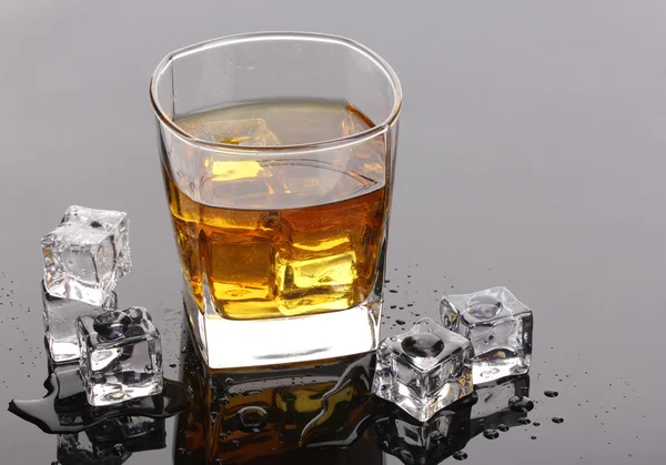 Sklo skotské whisky a ledu na šedou tabulku — Stock fotografie