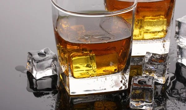 Dois copos de uísque escocês e gelo na mesa cinza — Fotografia de Stock