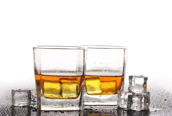 Zwei Gläser Scotch Whiskey und Eis auf dem Tisch isoliert auf weiß — Stockfoto