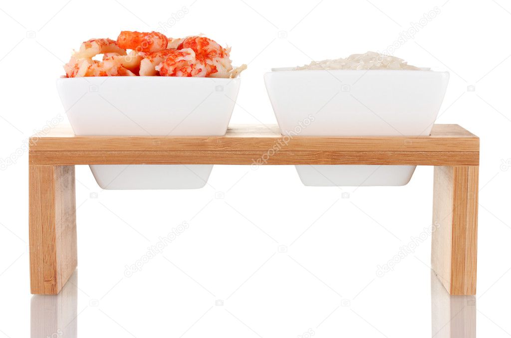 Rice and shrimp in bowls on wooden stand isolated on white
