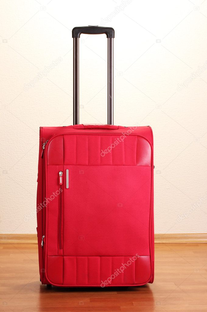 Red suitcase isolated in the room