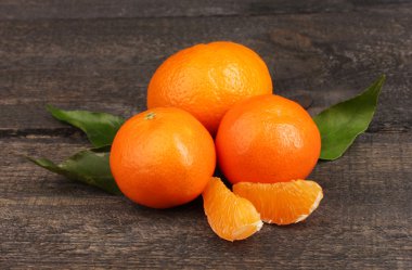 Tangerines with leaves on wooden grey table