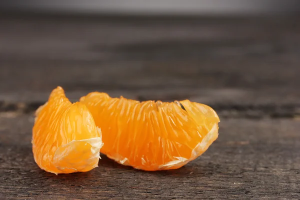 Due spicchi di mandarino maturi sul tavolo di legno grigio — Foto Stock