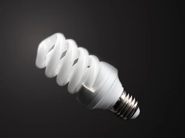 Lampe à économie d'énergie sur fond noir — Photo