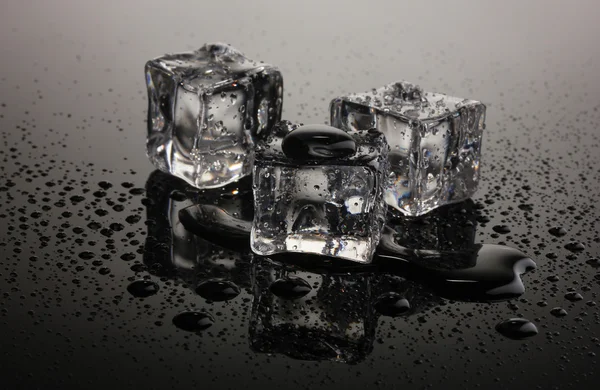 Derretimiento de cubitos de hielo sobre fondo gris —  Fotos de Stock
