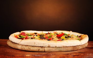 kahverengi zemin üzerine ahşap masa üzerinde sebze ile lezzetli pizza