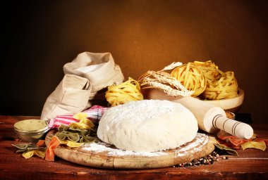 Ingredients for homemade pasta on wooden table on brown background clipart