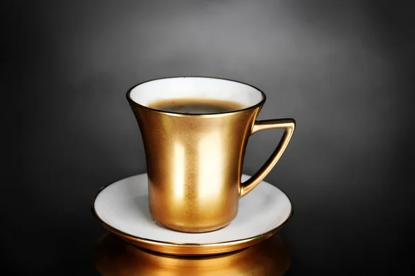 Gouden kopje koffie op grijze achtergrond — Stockfoto