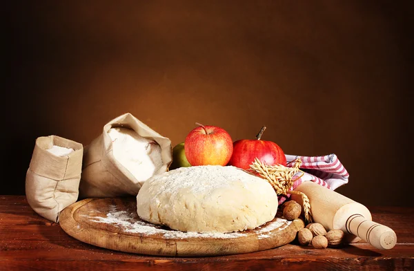 Ingrediënten voor zelfgemaakte taart op houten tafel op bruine achtergrond — Stockfoto