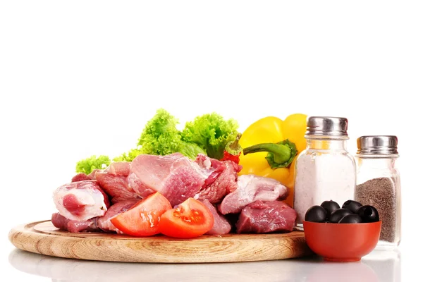 Bitar av rått kött och grönsaker på träplatta isolerad på vit — Stockfoto