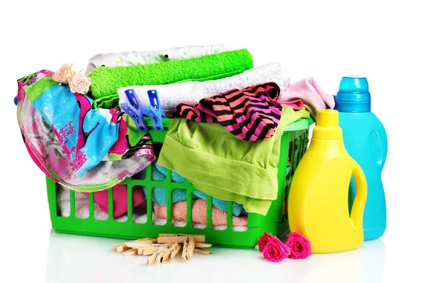 Ubrania z detergentem i zielony plastikowy kosz na białym tle — Zdjęcie stockowe