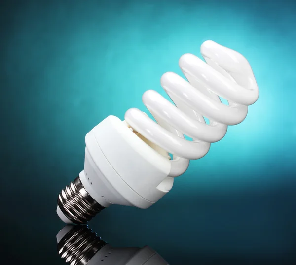 Energy saving lamp on blue background — Stock Photo, Image