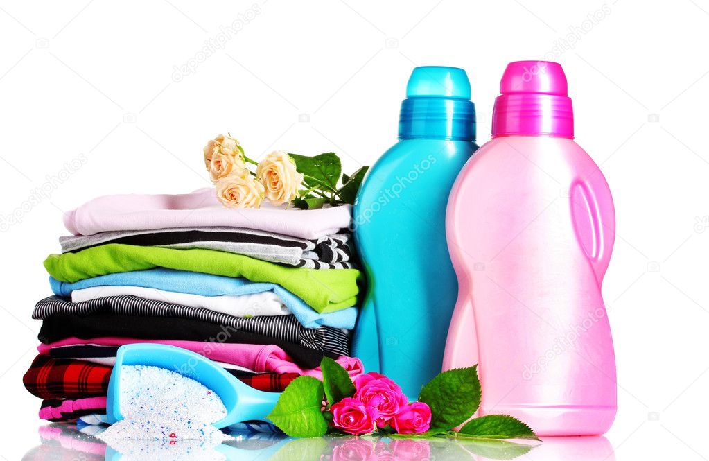 Detergent with washing powder and pile of colorful clothes isolated on whit