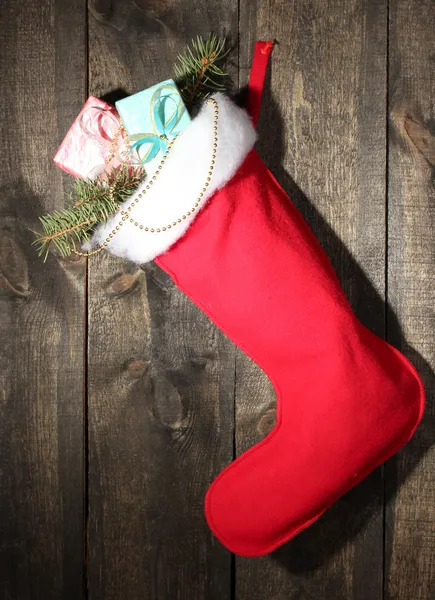 Julstrumpa med presenter på trä bakgrund — Stockfoto