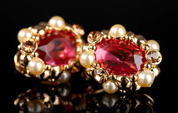 Belos brincos de ouro com rubis e pérolas sobre fundo preto — Fotografia de Stock