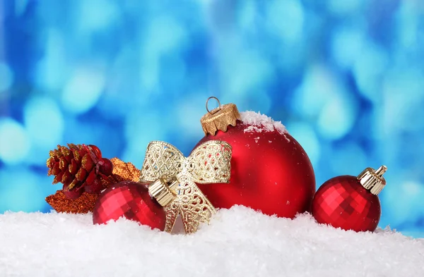 Vackra blå julgranskulor och filial i snö på blå bakgrund — Stockfoto