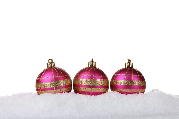 Hermosas bolas de Navidad de color rosa en la nieve aislada en blanco —  Fotos de Stock