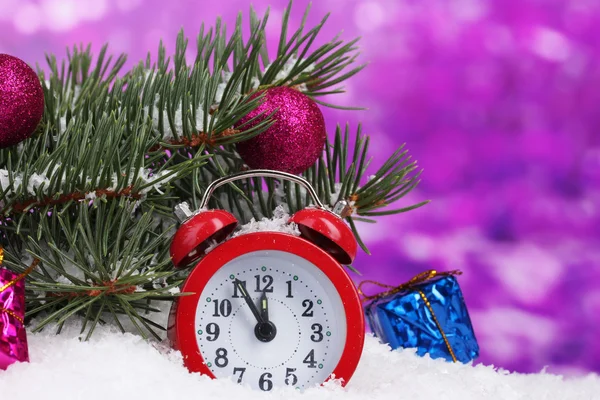 Grön julgran med leksak och klockan i snön på lila — Stockfoto