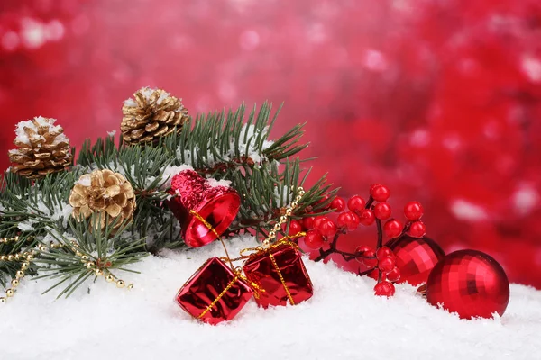 Boll och grön julgran i snön på röd — Stockfoto