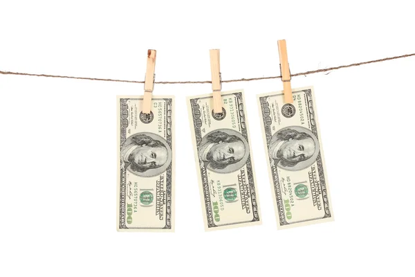 Three one hundred dollar bills is hanging on a rope with wooden clothespin — Stock Photo, Image
