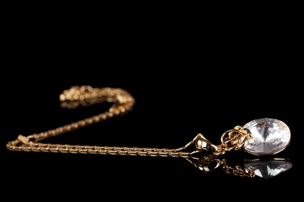 Krásný zlatý náhrdelník s drahokam na černém pozadí — Stock fotografie