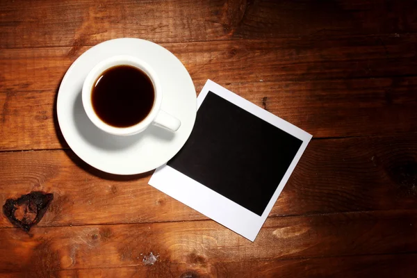 Papel fotográfico com café sobre fundo de madeira — Fotografia de Stock