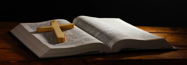 Rosyjski otwarte Pismo Święte z drewnianym krzyżem na stole — Zdjęcie stockowe