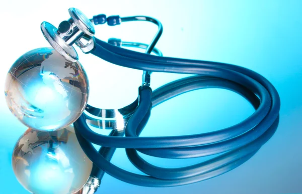 Глобус і стетоскоп на синьому — стокове фото